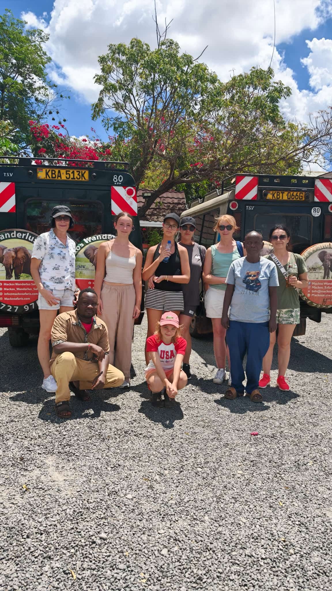 Safari guests and team with safari vehicles